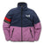 The Midtown Fleece Jacket is a kids’ fleece made from recycled polyester, featuring a navy blue top, light purple bottom, black zipper and pockets, one sleeve with red and gray stripes, town hall graphic, and a small chest logo.