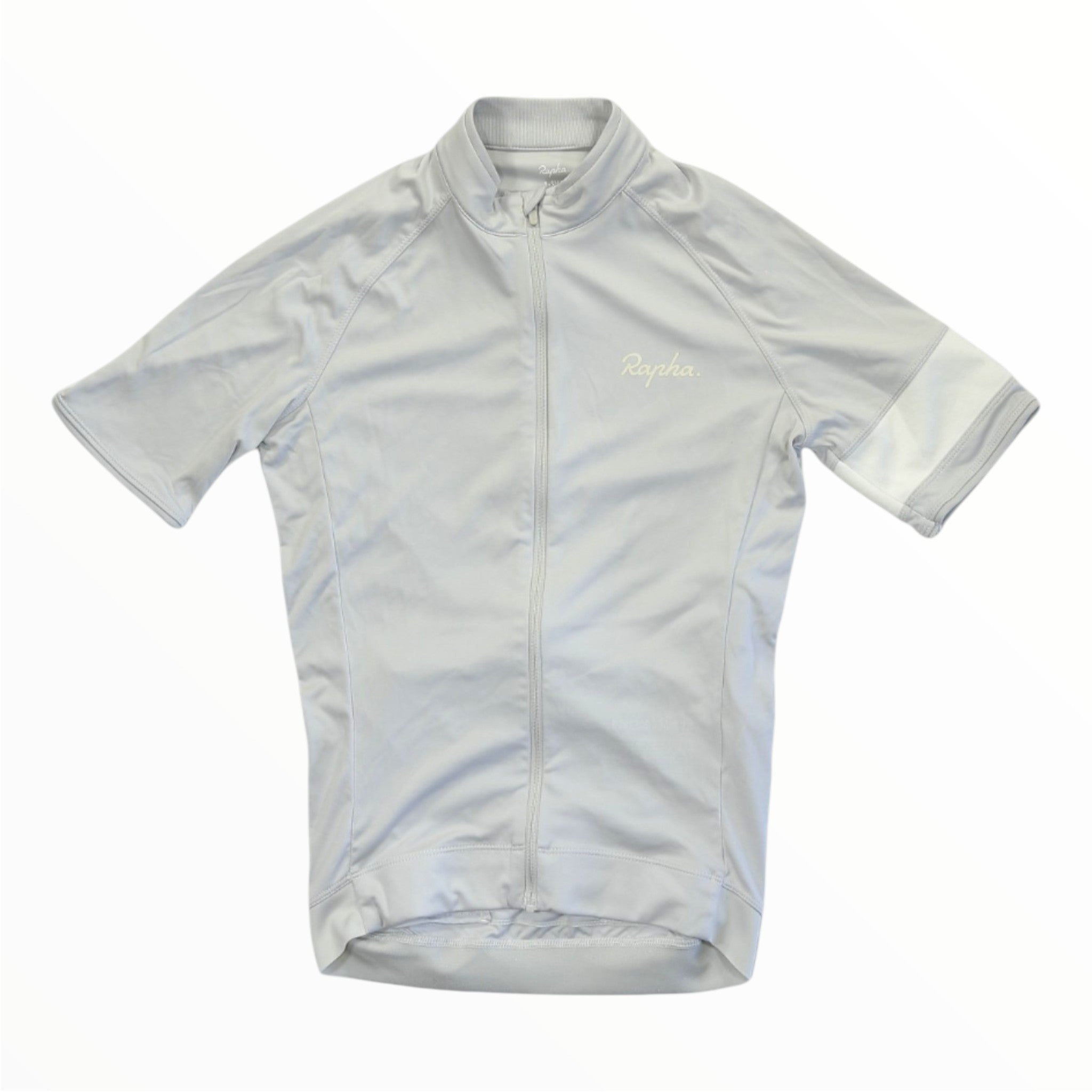 The Rapha Mens Core Jersey by Rapha is a light gray, short-sleeve cycling jersey featuring a full-length front zipper, a subtle chest logo, and a small white accent on the left sleeve. Laid flat on a white background, this premium men’s cycling apparel is an excellent choice for discerning riders.