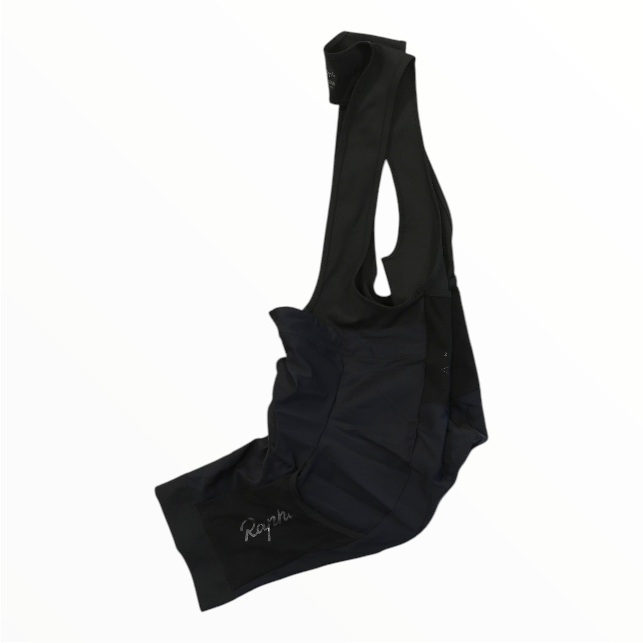 A pair of Rapha Mens Cargo Bib Shorts in black, featuring the brand name “Rapha” in white lettering on the leg and an award-winning chamois for superior comfort, displayed against a white background.