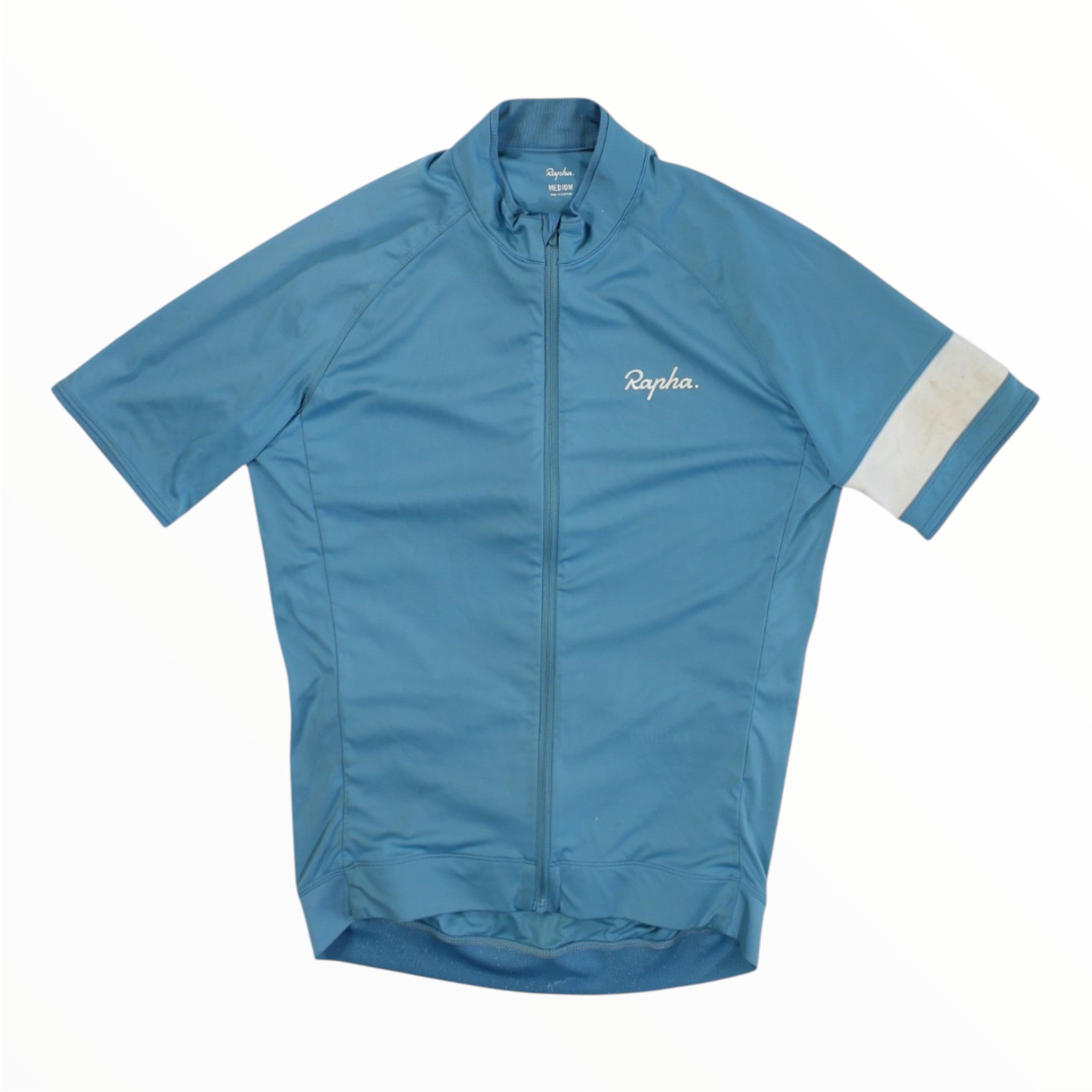 A blue Rapha Mens Core Jersey featuring short sleeves, a front zipper, a white Rapha logo on the chest, and a distinct white band on the left sleeve, showcased against a flat white background—an essential addition to men’s cycling apparel.