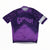 The Rapha Men’s Core Jersey by Rapha features a bold GRINDURO! logo across the chest, a distinctive purple and black color scheme, and a white stripe on the left sleeve—combining stylish design with comfort and performance for every ride.