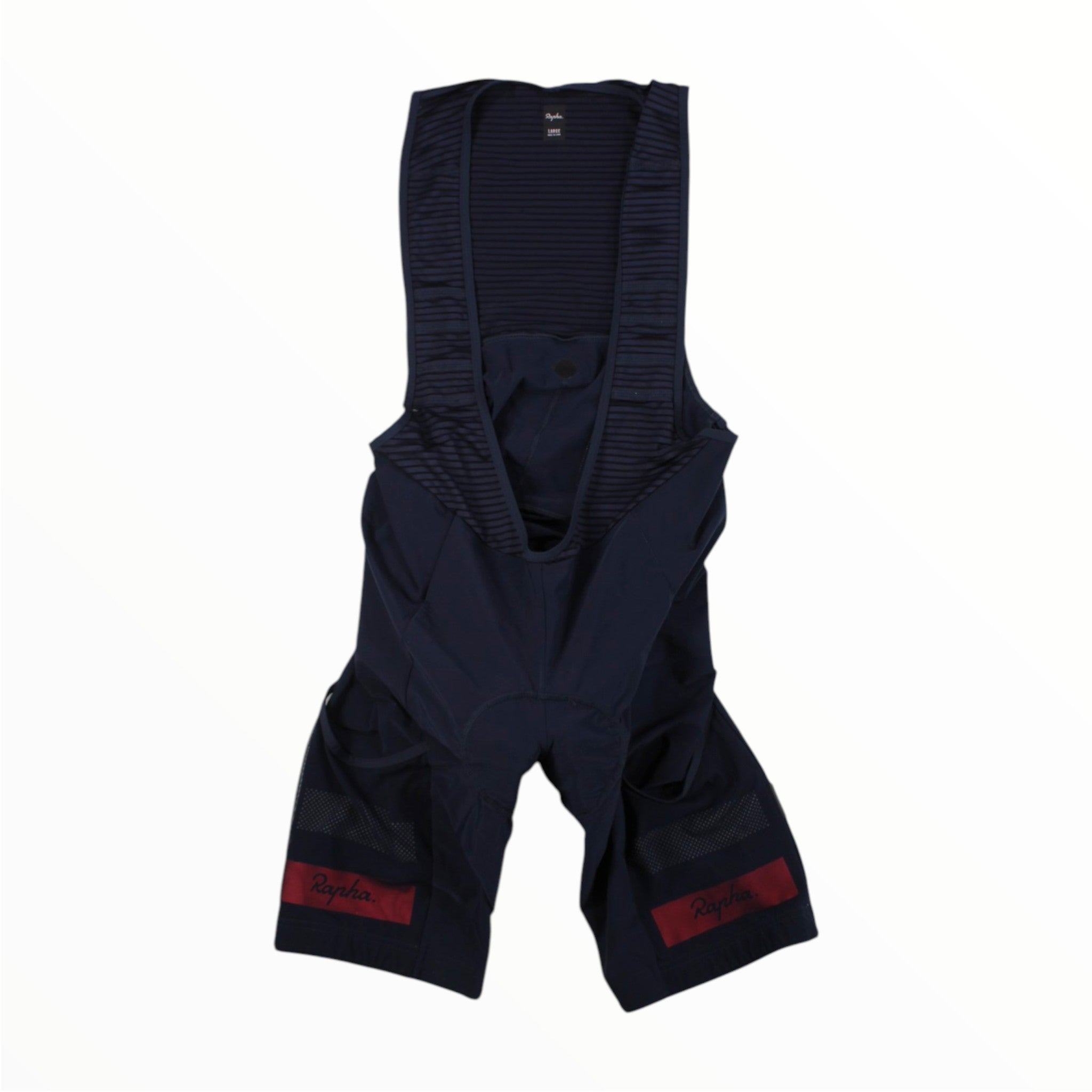 The Rapha Mens Cargo Bib Shorts by Rapha are shown in navy blue with mesh shoulder straps and two convenient side pockets. Red Rapha logos are placed above the knees, and the padded design ensures comfort and style for every cycling adventure. Displayed on a white background.