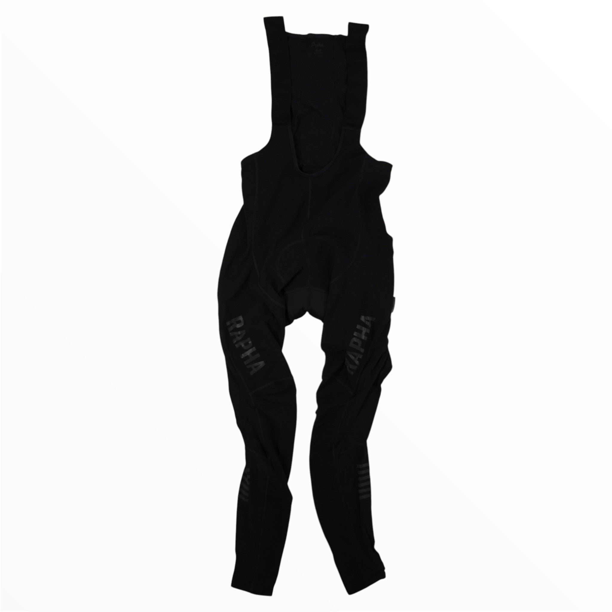 Black cycling bib tights with shoulder straps, featuring the word “RAPHA” printed in gray on both legs. Designed as part of the Rapha Mens Pro Team Winter Tights with Pad II collection by Rapha, these premium tights are an essential piece of winter cycling gear, shown against a plain white background.