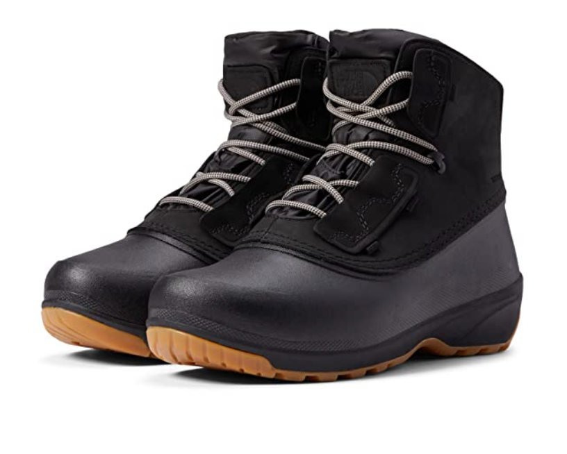 The North Face Women's Shellista IV Shorty WP Boot is a black, waterproof winter boot for women with rugged light brown soles, insulated lining, metal eyelets, and reinforced toe and heel areas for durable outdoor performance.