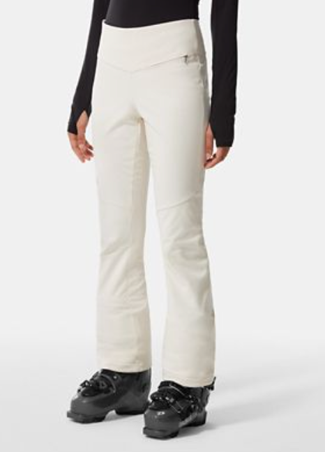 A person models The North Face Womens Snoga Pant with black ski boots, standing against a plain white background. Only the lower half of their body is visible.