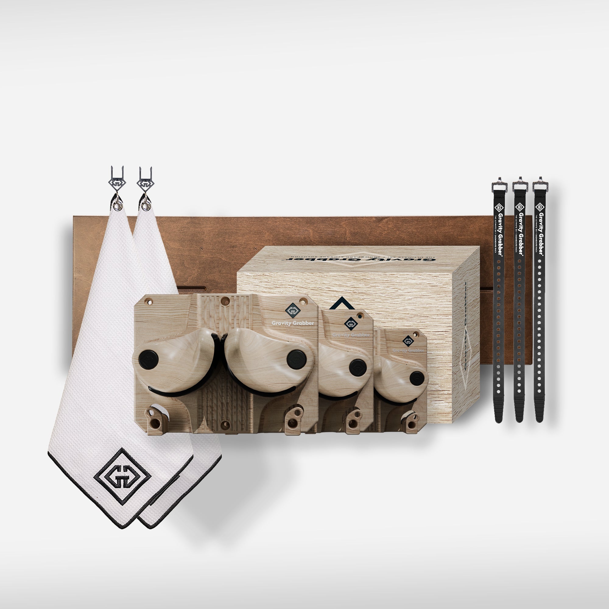 The Wood Bundle Maple Board includes three maple hangboards in different sizes, a wooden box, two white hooked towels, and three black straps—ideal for garage storage—shown on a white background.