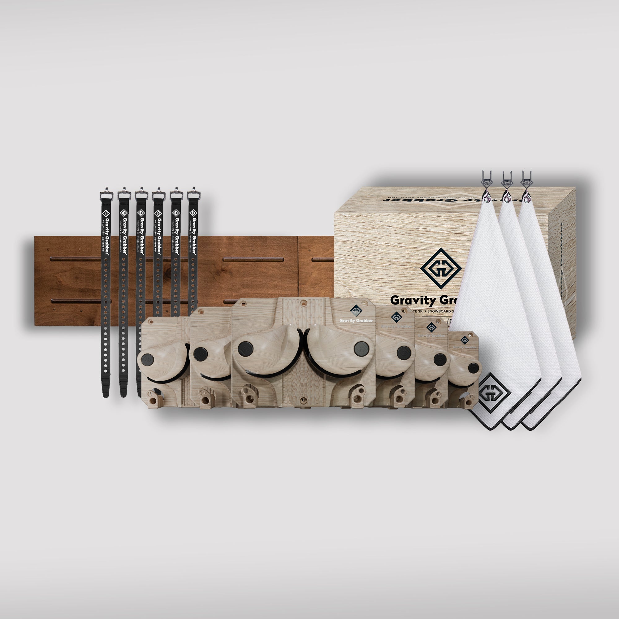 The Wood Bundle Maple Board features wall-mounted shelves, a ski and snowboard rack, four white logo towels, five black straps, and a large wooden Gravity Grabber box—displayed on a plain background.