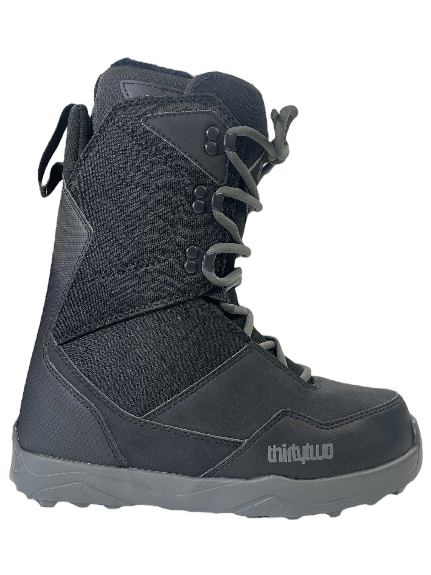 The Thirty Two Shifty W Women's Snowboard Boots feature a black design with gray laces, rugged sole, reinforced stitching, comfort fit liner, and thirtytwo branding near the side toe.