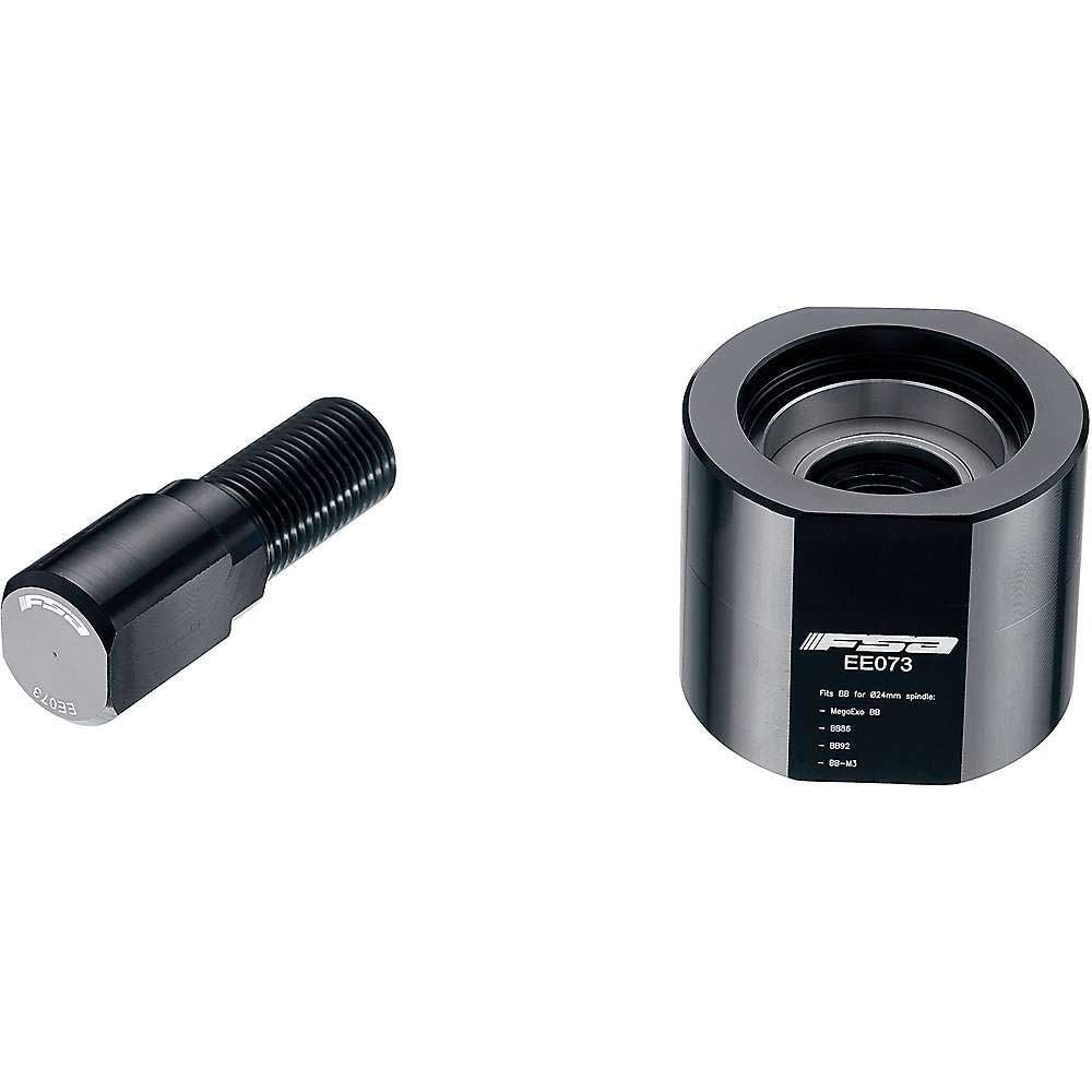 The Full Speed Ahead Bottom Bracket Rebuild Tool, a cylindrical metal tool with engraved labeling, is shown next to a black threaded bolt on a white background.