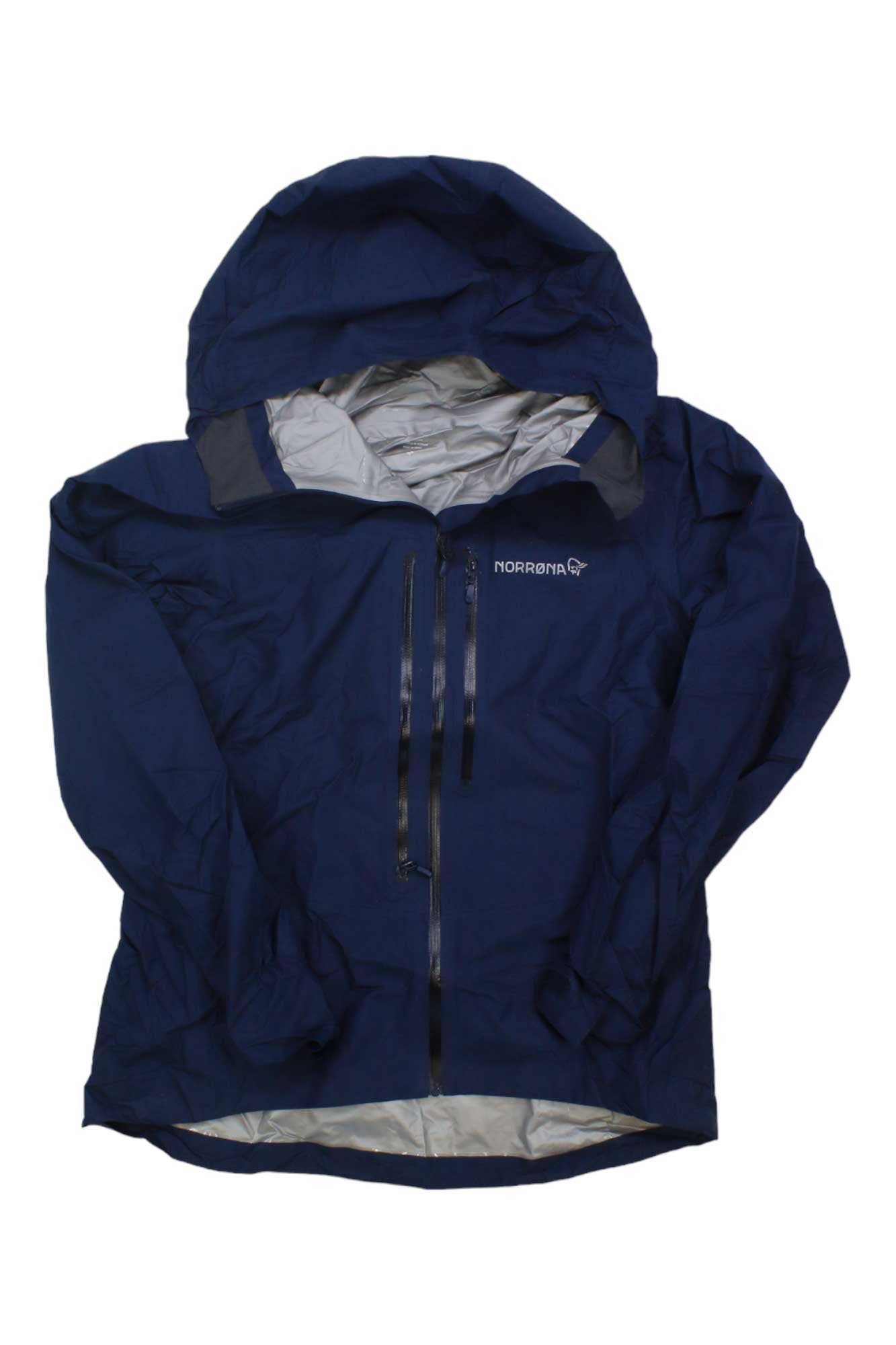 The Norrona Womens Falketind GTX Paclite Jacket is a navy blue, waterproof, breathable shell with a front zipper, two zippered chest pockets, the Norrona logo on the left chest, and a light gray interior lining.