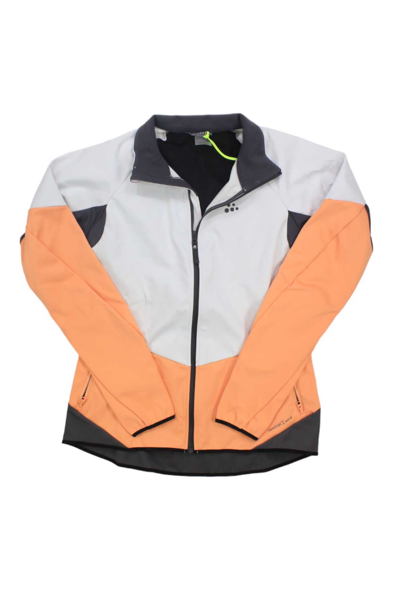 The Craft Sportswear Women's Glide Jacket is waterproof and windproof, ideal for cold-weather activities. It features color-blocking in light gray, peach, and black, plus a front zipper and zippered pockets for extra functionality.