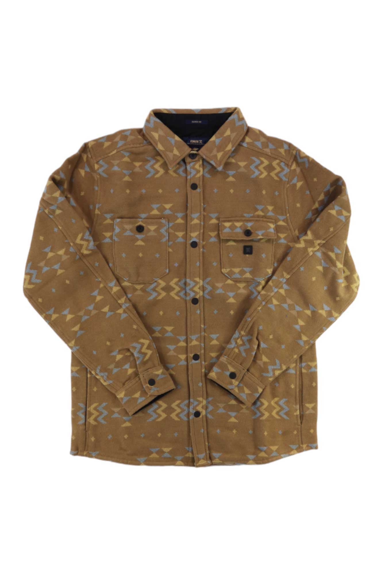 The Roark Men's Andes Shirt is a brown heavyweight flannel with a light blue and beige geometric tribal pattern, two chest pockets, and black buttons—ideal as a casual overshirt for travel or relaxed days.