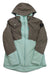 The Obermeyer Women's Cecilia Jacket is a two-tone insulated waterproof jacket with a brown upper and mint green lower section, front zipper, zippered pockets, and a black sleeve patch—ideal for winter or skiing.