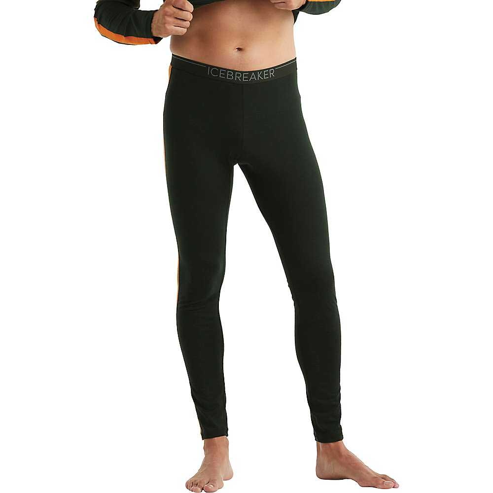 A man stands barefoot against a white background, wearing black Icebreaker Mens 200 Sonebula Leggings—odor-resistant merino wool base layer—with his upper body mostly out of frame.