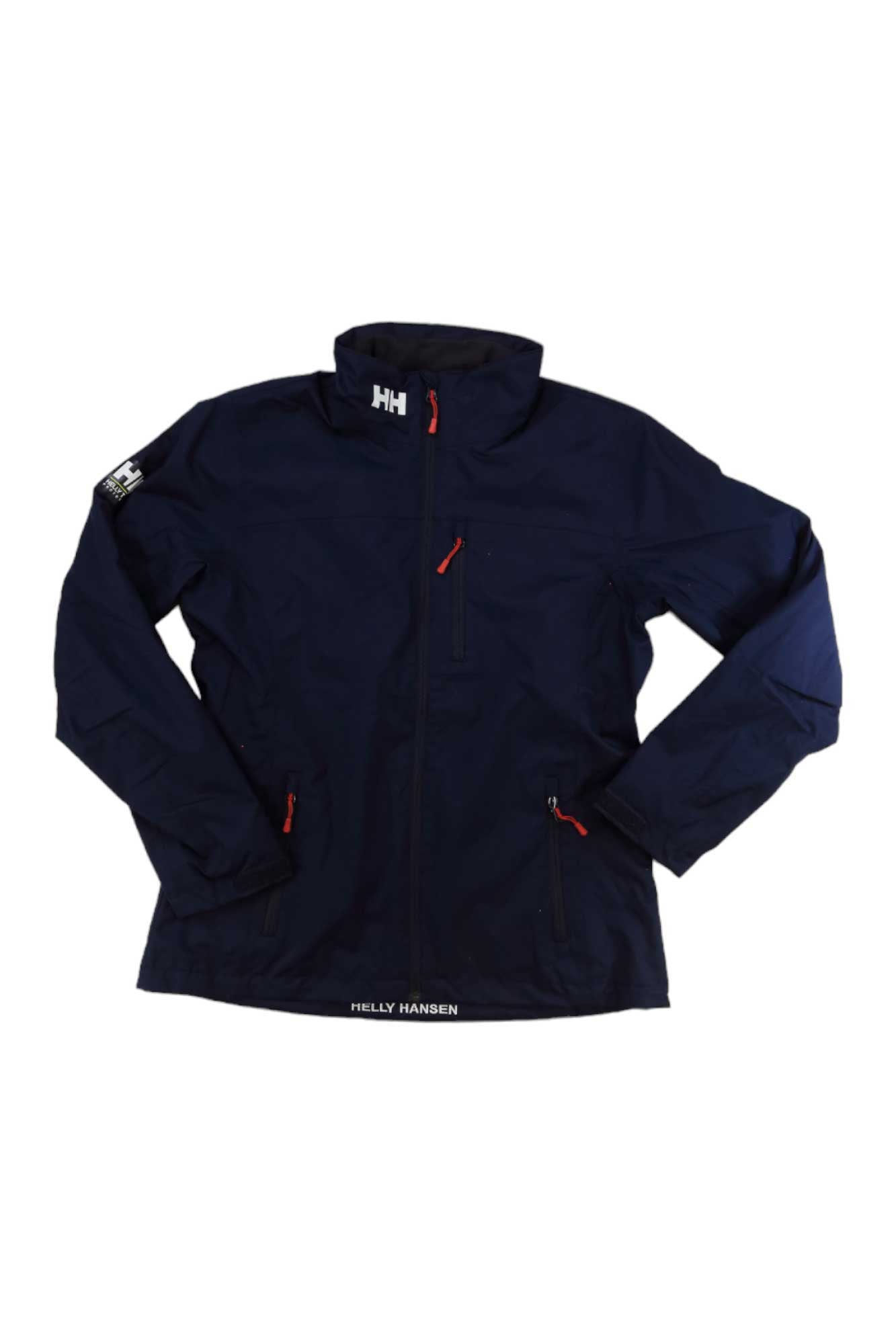 The Helly Hansen Womens Crew Midlayer Jacket is navy blue with a high collar, red zipper pulls, chest logo, and patch logo on the upper left sleeve. This waterproof jacket features zippered pockets for secure storage.