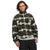 A person with shoulder-length brown hair faces forward in The North Face Mens Campshire Fleece Jacket, which displays black, gray, and cream zigzag shapes. They have a neutral expression and stand against a white background.