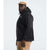 A man in The North Face Men's Big Alta Vista Jacket—a black waterproof hiking jacket made from recycled nylon—stands sideways against a plain light background. He also wears a light brown cap and khaki pants. The jacket has a small white chest logo.