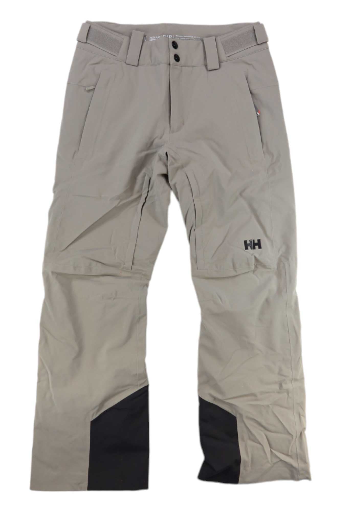 The Helly Hansen Mens Rapid Pant in light beige features belt loops, front pockets, reinforced black inner ankle patches, and the HH logo on the right thigh. These insulated ski pants are shown laid flat on a white background.