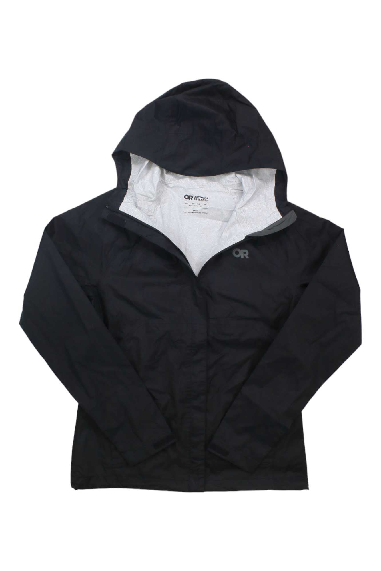 The Outdoor Research Womens Apollo Jacket is a black waterproof jacket with a hood, front zipper, light gray interior lining, and the OR logo on the left chest. It's shown laid flat with sleeves spread out.