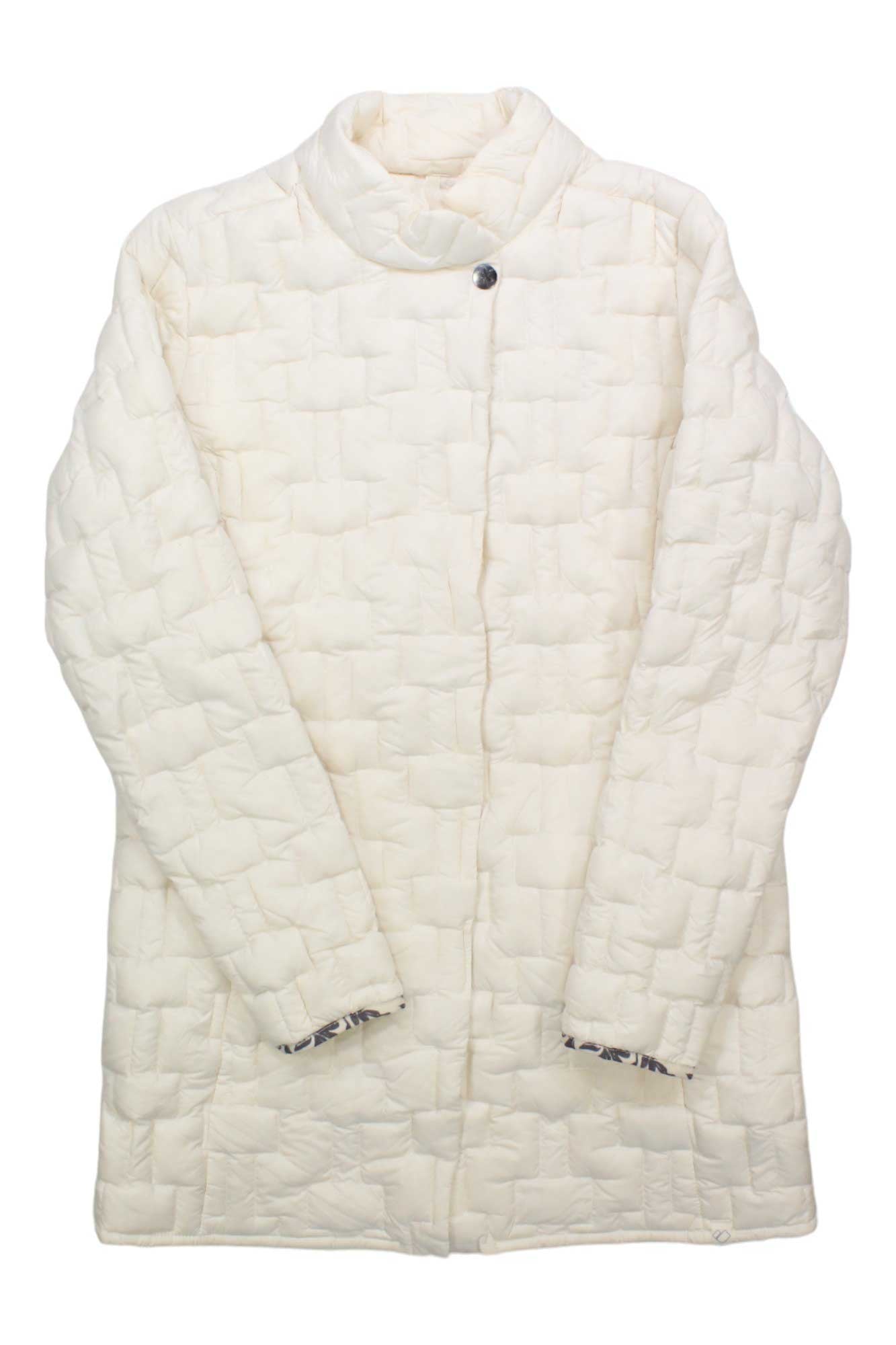 The Obermeyer Womens Perry Down Parka is an off-white, long-sleeve insulated jacket with a high collar, single visible neck button, and a grid-like texture. It’s shown laid flat with arms crossed at the wrists.