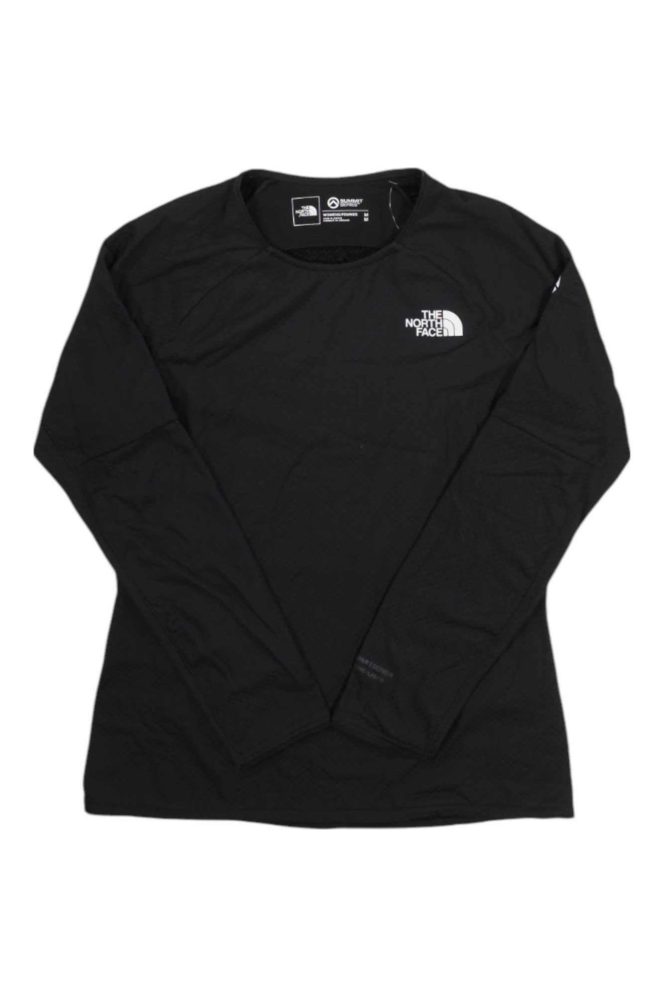 The North Face Womens Summit Futurefleece Crew Top is a black long-sleeve crew neck fleece with a white logo on the left chest and inside collar, inspired by outdoor adventures. Laid flat on a white background.