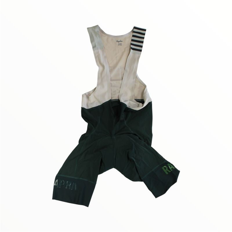 A pair of black Rapha Mens Pro Team Bib Shorts II - Long with white shoulder straps, green RAPHA branding on the legs, and a dual-density chamois pad, shown on a white background.