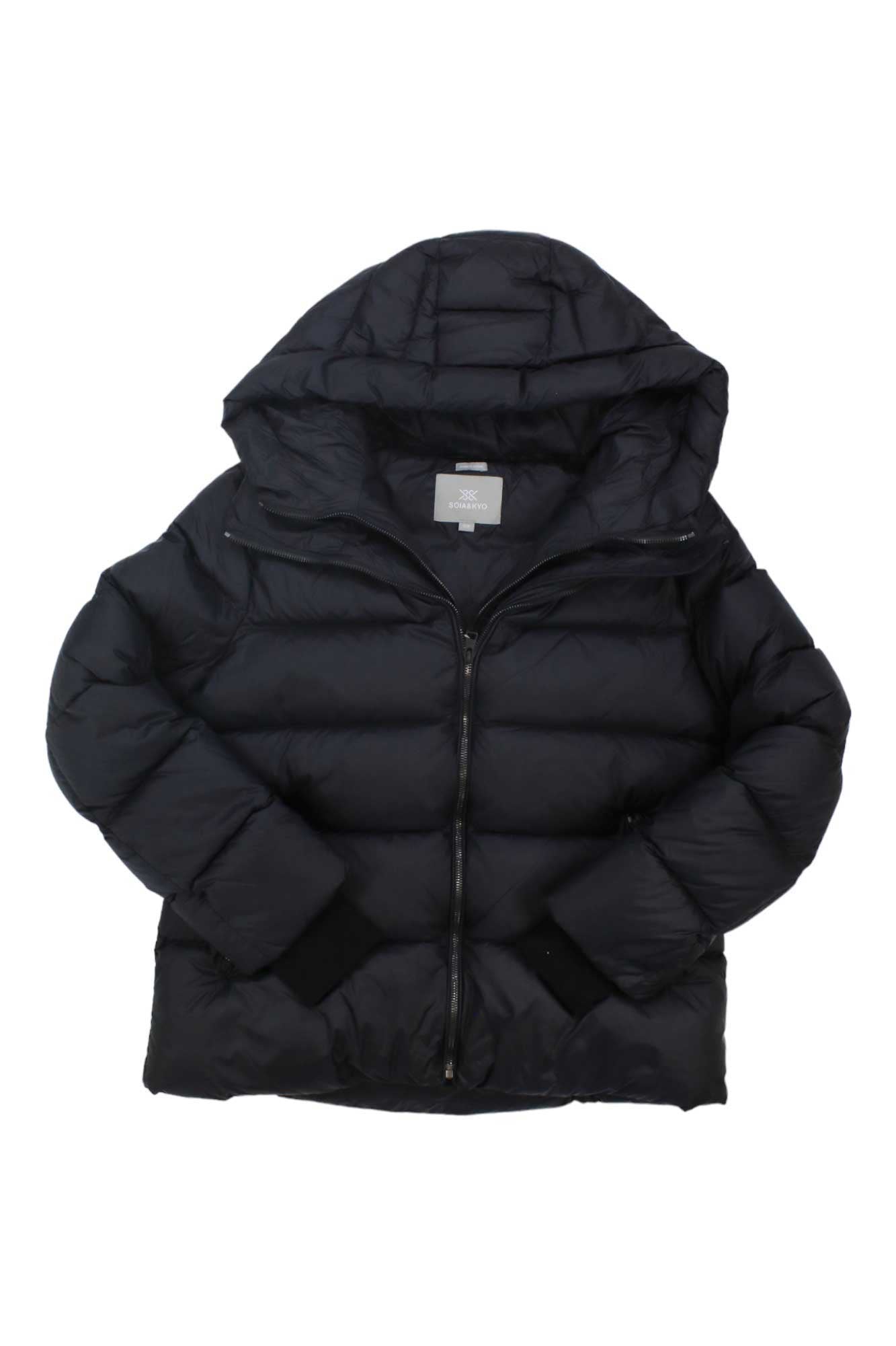 The Soia & Kyo Women's Cassia Jacket is a black, hooded down coat with long sleeves and a front zipper, laid flat on a white background. This sustainable winter jacket offers chic, cozy style inspired by the original Cassia design.