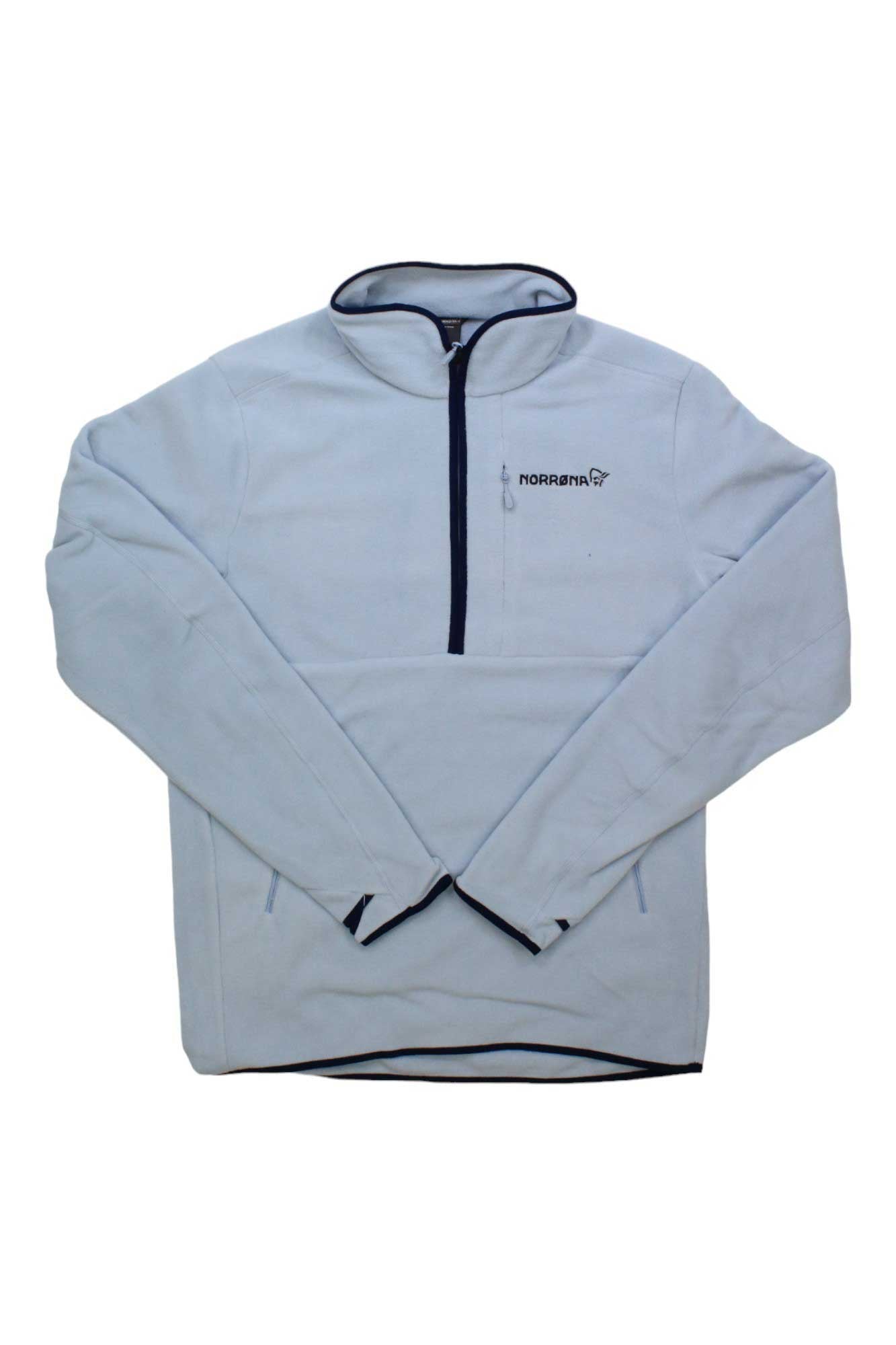 The Norrona Warm2 Halfzip Top is a light blue fleece with black trim, made from recycled polyester midlayer fabric. It features a half-zip front, Norrona logo on the left chest, and is an ideal insulating layer for outdoor use.