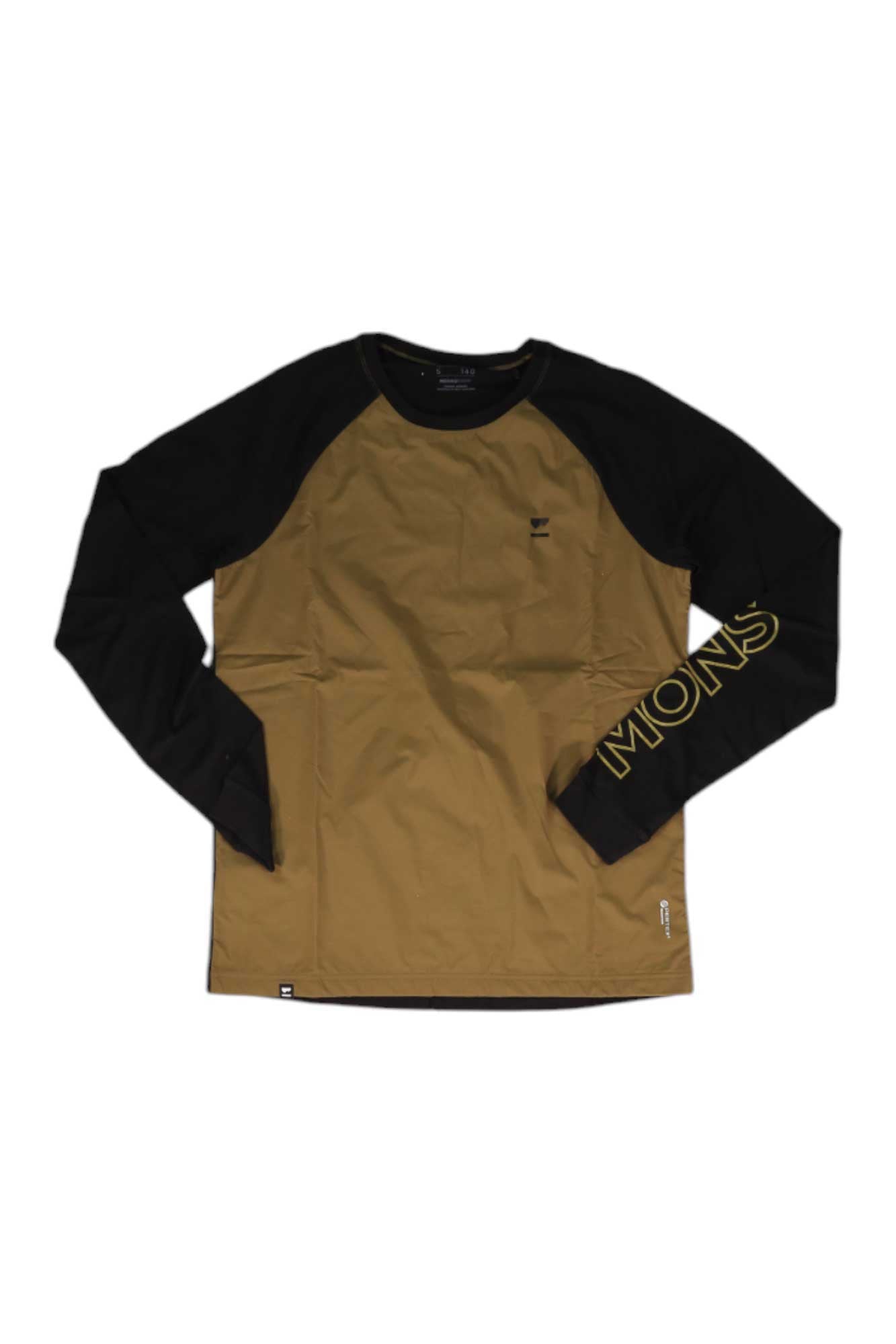The Mons Royale Men's Tarn Merino Shift Wind Jersey is a long-sleeve biking shirt with black sleeves, a brown merino wool body, 'MONS' in yellow on the left wrist, a classic crew neck, and a small bottom tag.