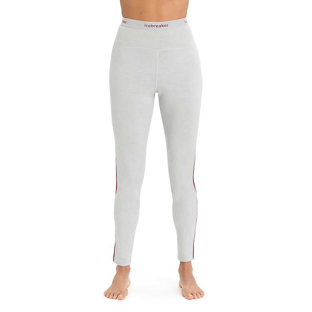 A person stands barefoot in Icebreaker Women's 200 Sonebula Legging—light gray merino wool leggings with a high-waisted branded waistband, slim fit, and subtle red side stripe—ideal for fitness enthusiasts.