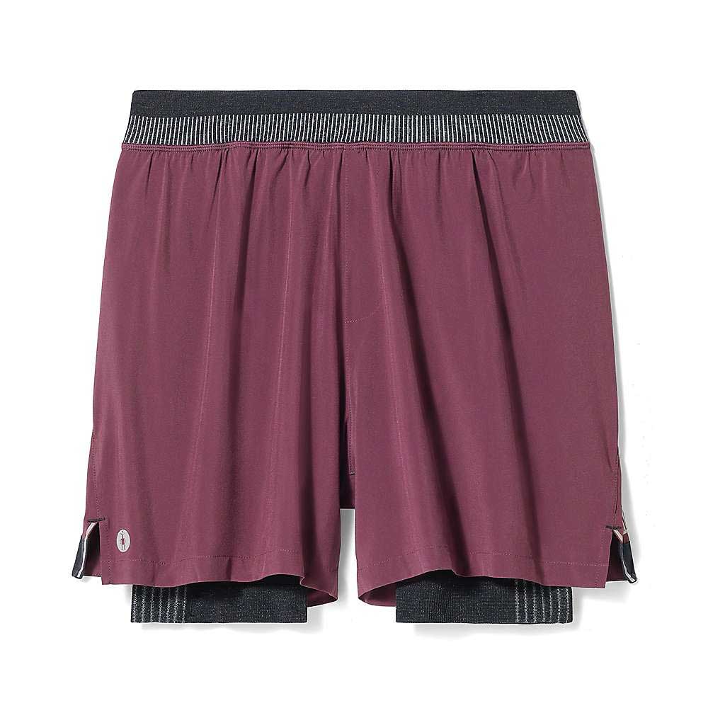 The Smartwool Men's Intraknit Active Lined 5 Inch Short features a maroon color, black elastic waistband, built-in black compression liner, small side slits for mobility, and a reflective logo by the left hem for visibility.
