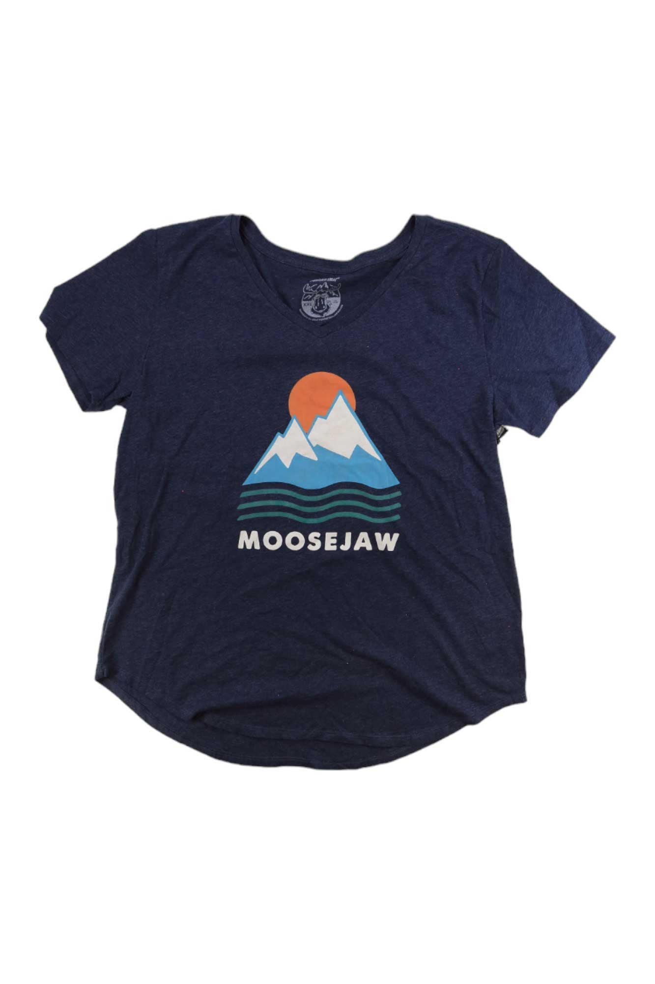 The Moosejaw Womens Iceberg Salad Flowy V-Neck SS Tee is a navy blue organic cotton top with a sun setting behind white mountains, blue stripes, and MOOSEJAW printed below the graphic for all-day comfort.