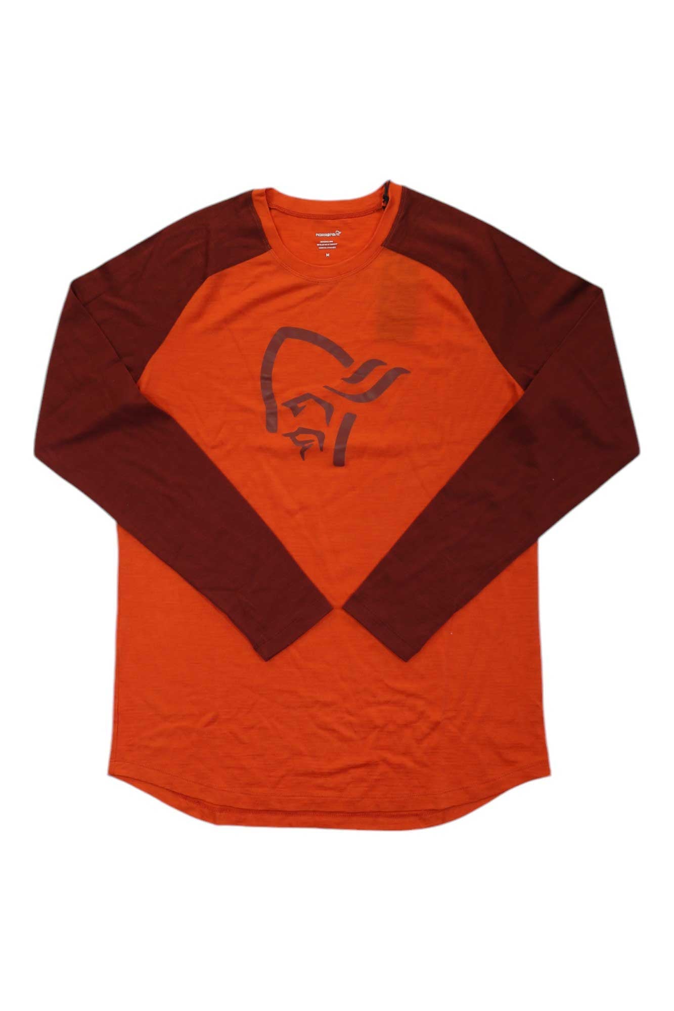 The Norrona Mens Pureull LS Top is an orange long-sleeve base layer with dark red raglan sleeves, featuring a stylized helmeted face graphic on the front and designed for moisture-wicking comfort.