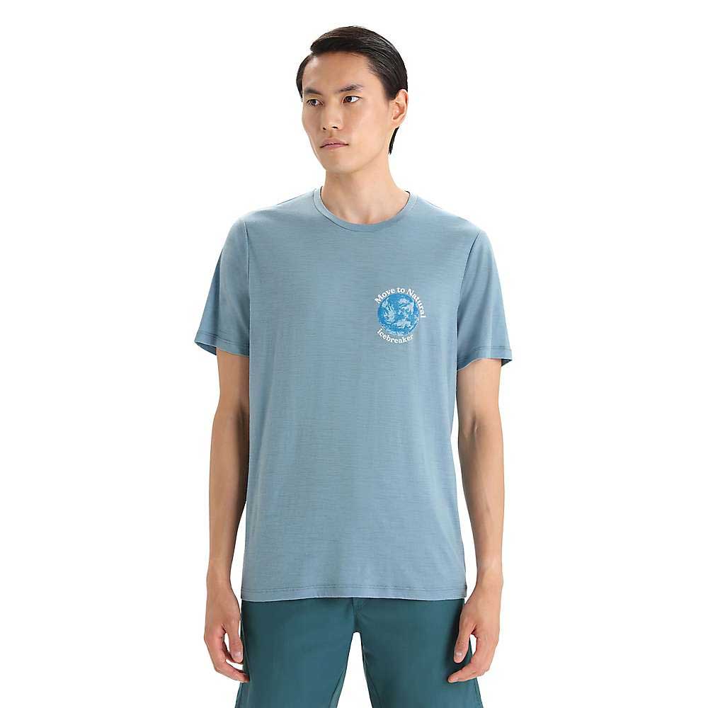 A man with straight dark hair wears the Icebreaker Mens Tech Lite II SS Tee in light blue with a small circular logo on the left chest and teal pants, standing against a white background.