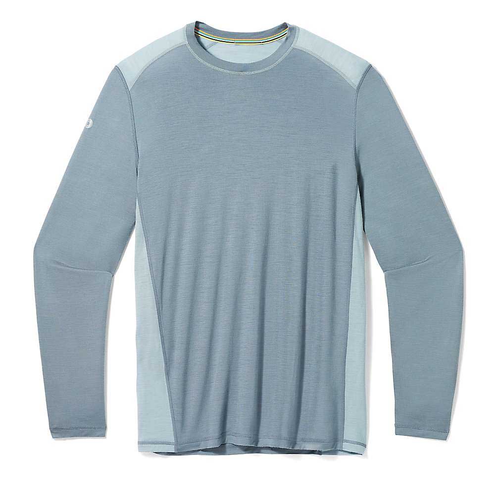 The Smartwool Mens Active LS Tech Tee features long sleeves and comes in two light blue shades, with darker blue on the front and sleeves and lighter blue on the shoulders and sides. Perfect for hiking, it's shown laid flat on a white background.