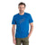 A man with short brown hair and a beard wears the Icebreaker Mens Merino 150 Tech Lite II Natural Ski Tour SS Tee, a bright blue Merino wool shirt with a minimalist three-hiker graphic, standing against a white background with one hand in olive-green pants pocket.