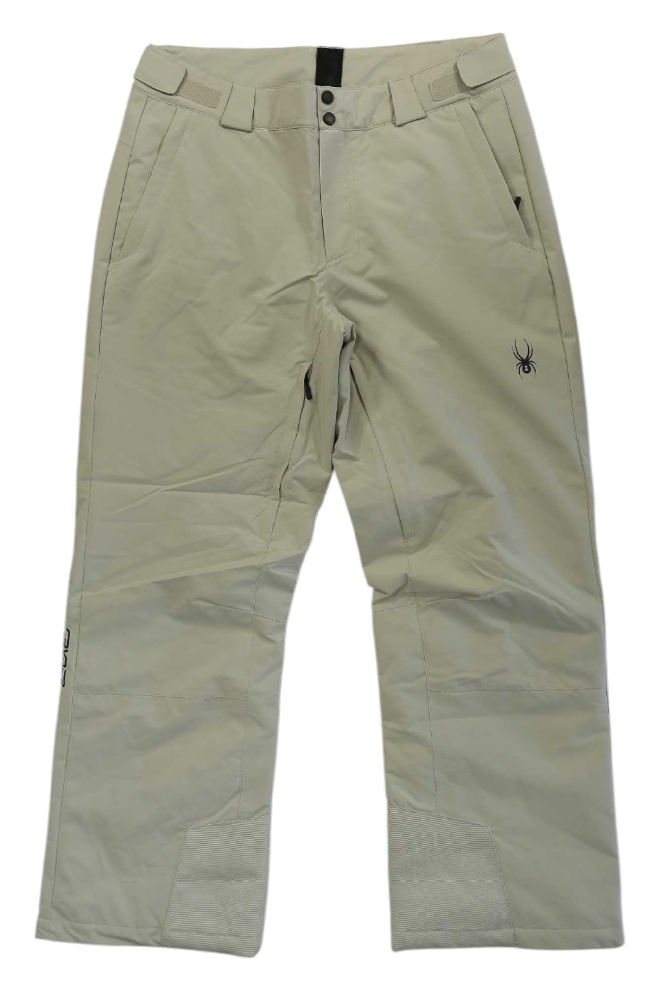 The Spyder Mens Traction Pant in beige features waterproof skiing design, zip and snap front closure, zippered side pockets, reinforced cuffs, PrimaLoft ECO insulation, and a small black spider logo on the upper right leg. Laid flat on white.
