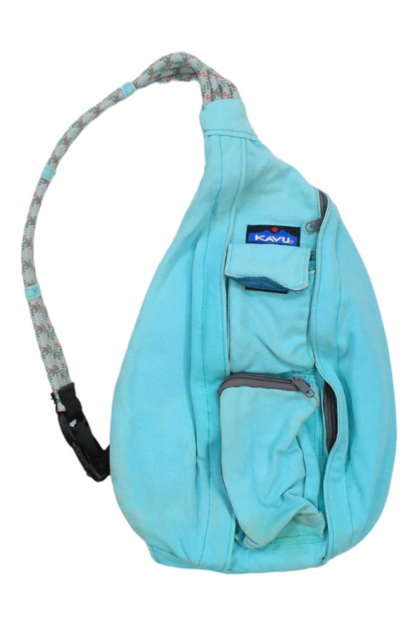 The Kavu Rope Sling Bag features a light blue color, patterned rope strap, front zipper pockets, and KAVU logo tag—making it a stylish, weather-resistant sling bag ideal for everyday use.