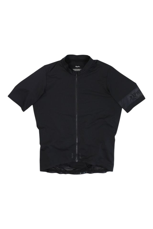 The Mens Pro Team Midweight Short Sleeve Jersey is a plain black men's cycling jersey with a full front zipper and subtle RAPHA text on the left sleeve, inspired by the iconic Rapha Pro Team midweight style.