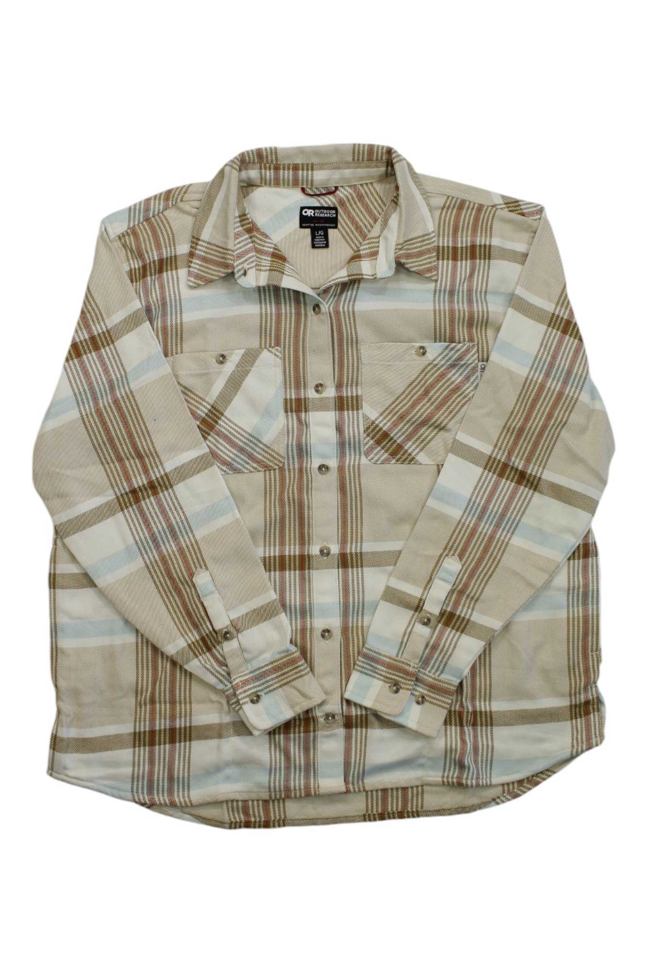 The Outdoor Research Women's Feedback Flannel Twill Shirt in beige, brown, and light blue plaid features moisture-wicking fabric and two chest pockets, shown laid flat on a white background.