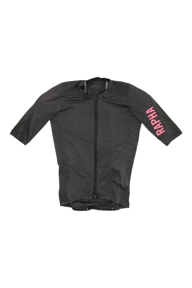 The Pro Team Aero Jersey II is a black, short-sleeve cycling jersey featuring a front zipper and pink RAPHA lettering on the left sleeve.