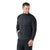 A man wears the Smartwool Men's Intraknit Merino Insulated Jacket—black, fitted, with ribbed sleeves and side pockets—standing slightly to the side, looking down with a slight smile against a plain white background.