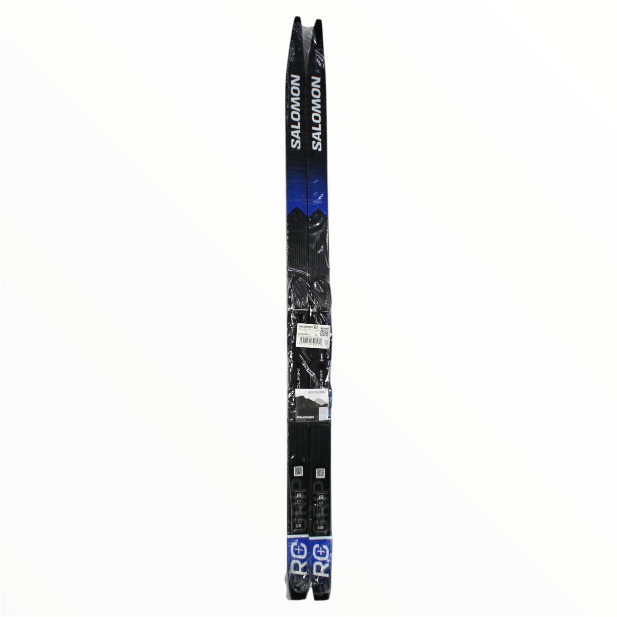 The Salomon Juniors RC+ Grip Ski with Prolink Access Binding, in black and blue, stand upright side by side against a white background.