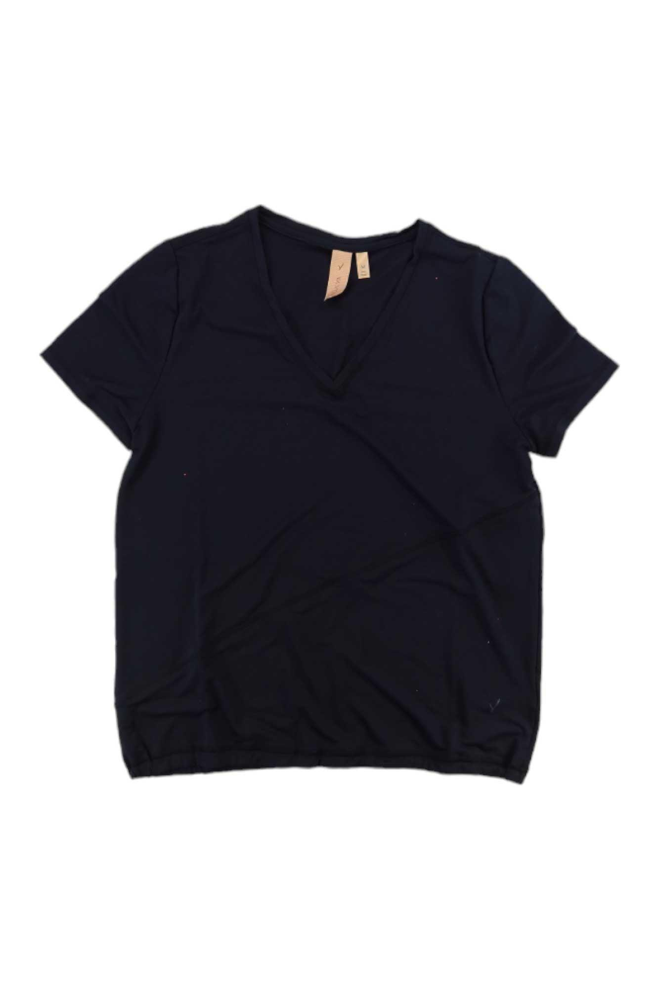 The Indyeva Womens Kurak LT Top, a plain black short-sleeve V-neck travel T-shirt with UPF 50+ protection, is shown laid flat on a white background with a beige tag attached at the neckline.