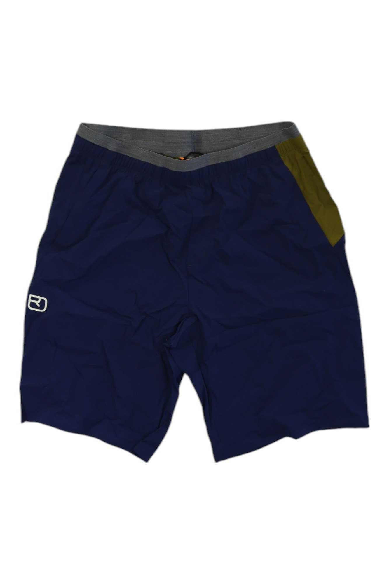 The Ortovox Mens Piz Selva Light Short features navy blue fabric, a gray elastic waistband, a green right-side pocket, and a small white logo on the left leg. Lightweight and breathable, they're ideal for hiking or climbing and shown laid flat on a white background.