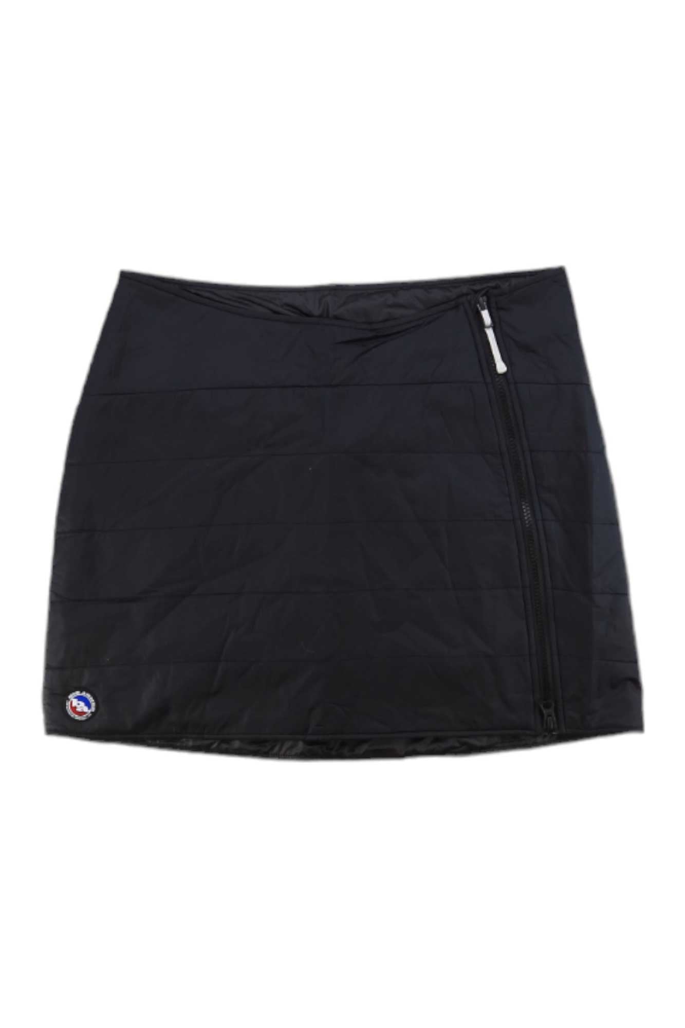 The Big Agnes Women's Columbine Skirt is a black, quilted ultralight insulated mini skirt with an asymmetrical right zipper and a small circular logo near the bottom left hem.