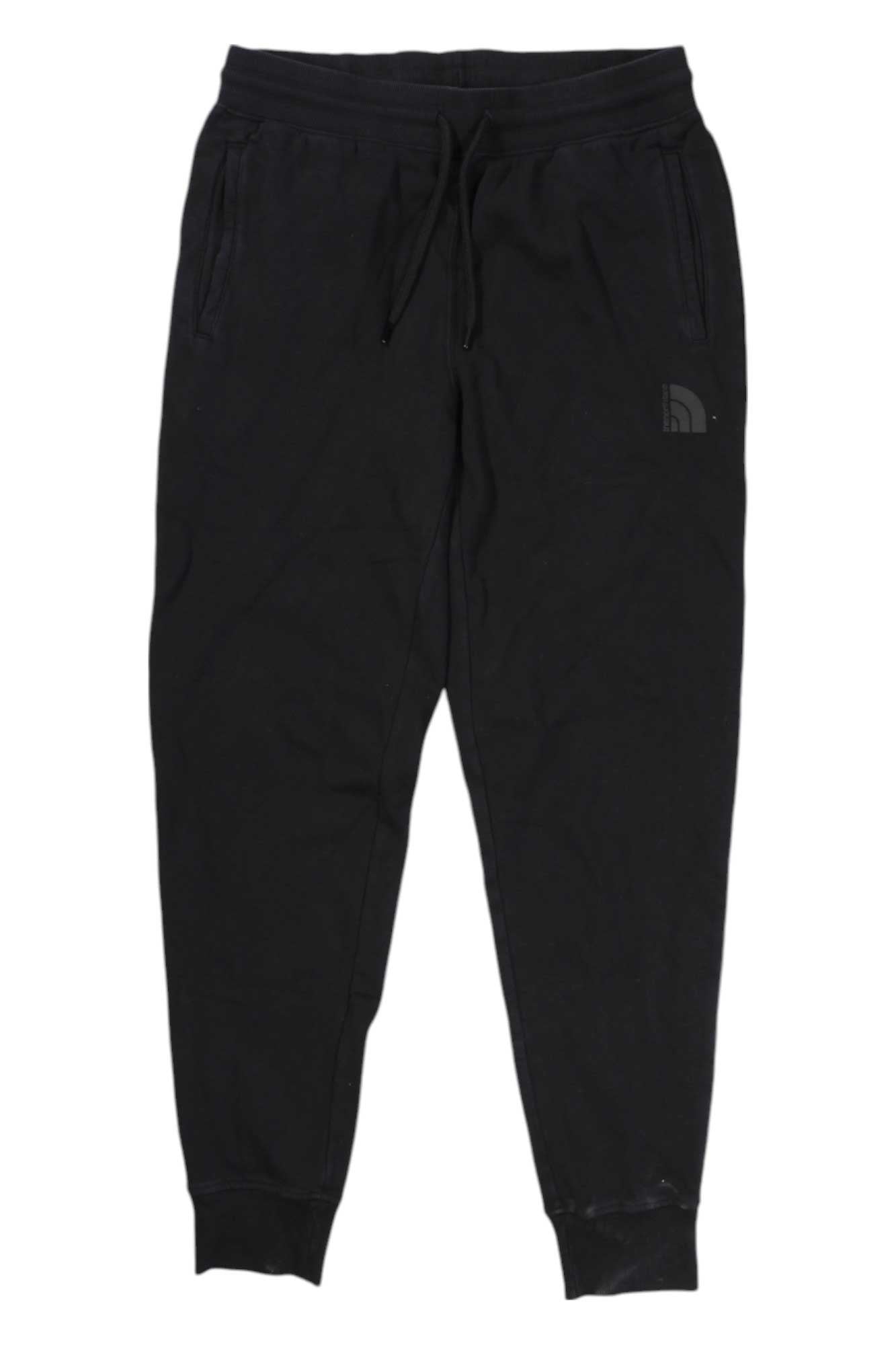 The North Face Womens Garment Dye Jogger features an elastic waistband, drawstring, side pockets, ribbed cuffs, and a small logo on the upper left thigh. Versatile black activewear shown on a plain white background.
