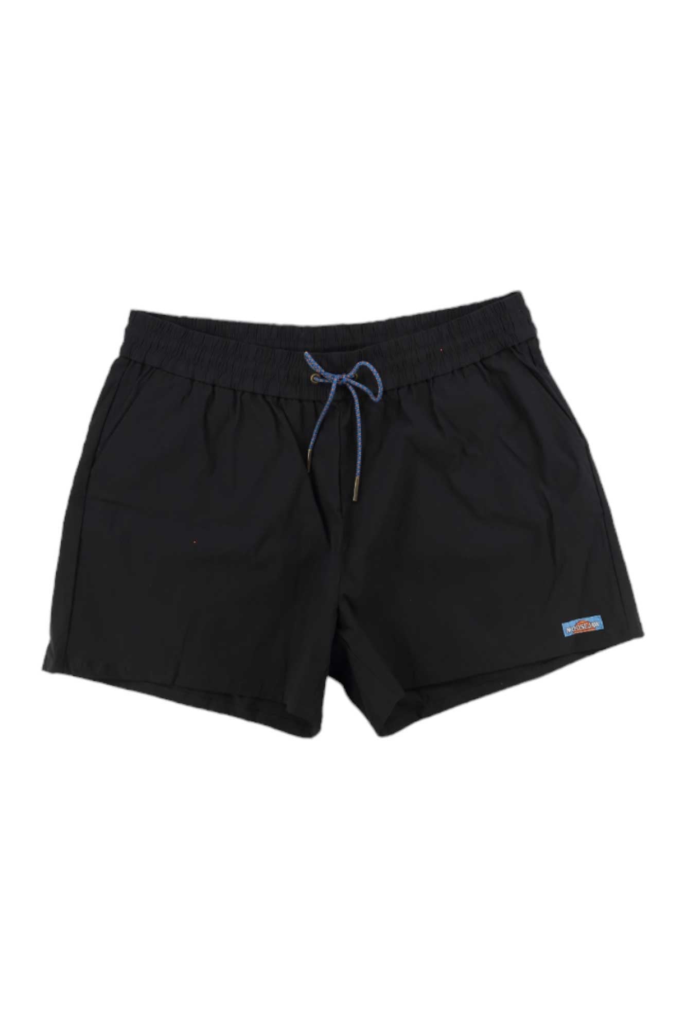 The Moosejaw Womens THE Moosejaw Short is a pair of black quick-drying shorts with an elastic waistband and blue drawstring, plus a rectangular logo patch on the left hem—ideal as stylish hiking shorts for active days.