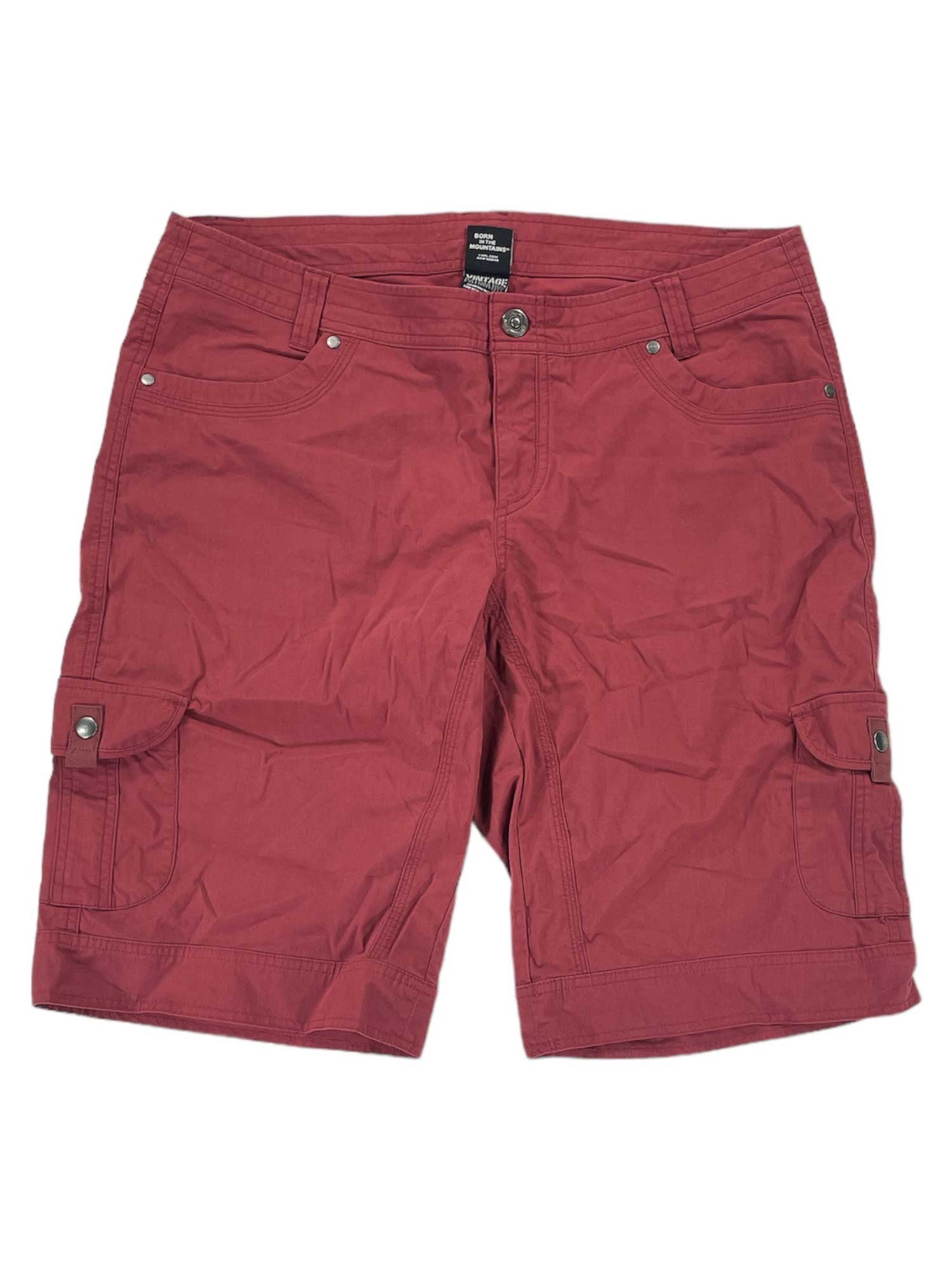 A pair of red women's KUHL Splash 11 Shorts, knee-length and wrinkled, made from a performance cotton blend with side pockets, front button closure, and belt loops, laid flat on a white background.