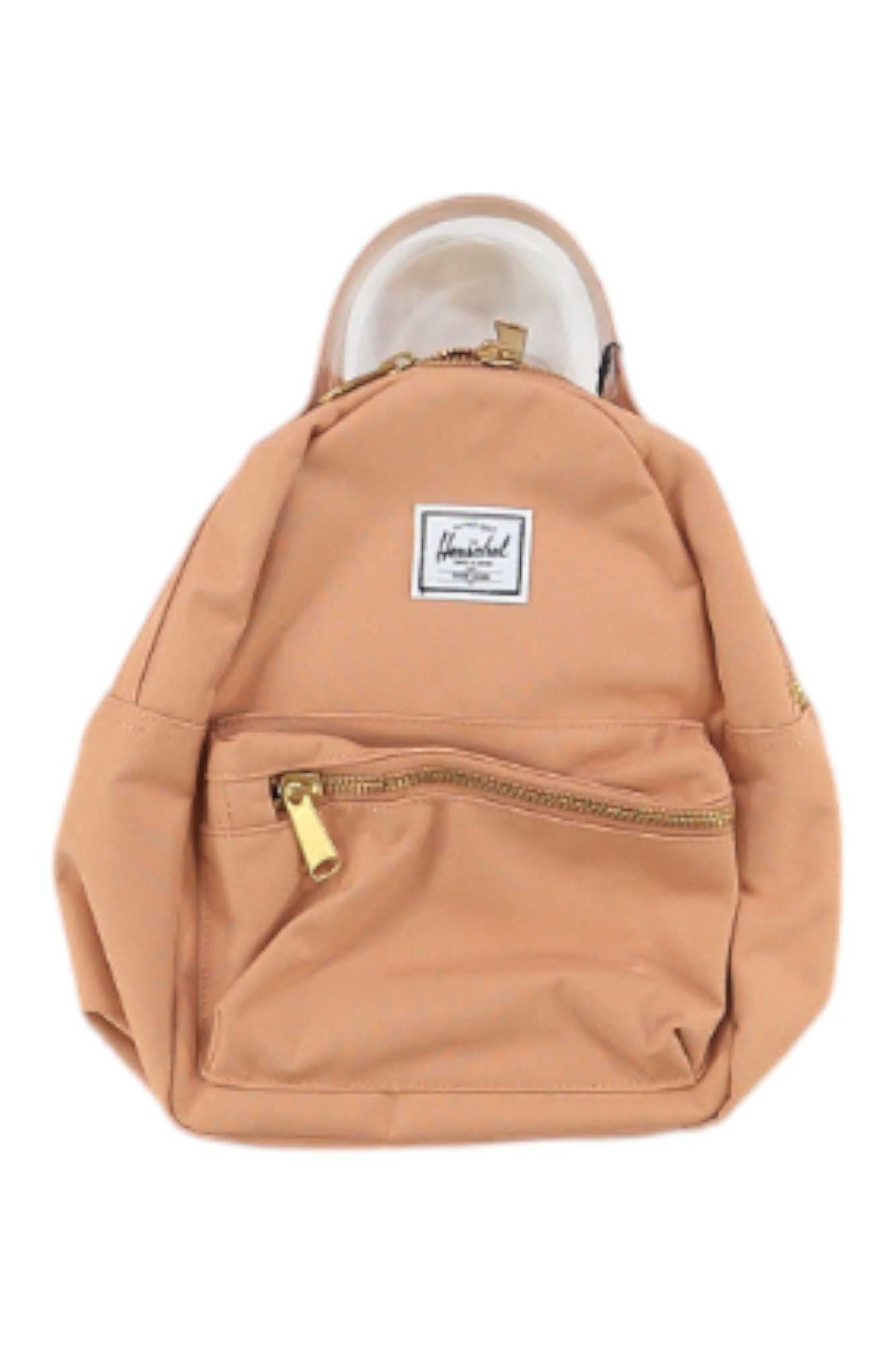 The Herschel Supply Co Nova Mini Backpack is light brown with a front zipper pocket, gold metal zippers, adjustable straps, and a white front label. Displayed against a white background.